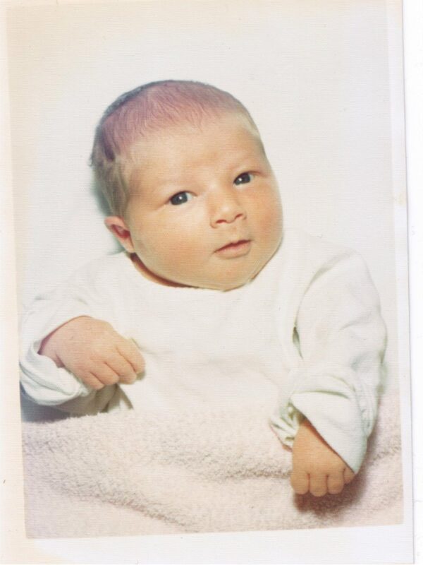 A newborn stares into the camera with wide open eyes.