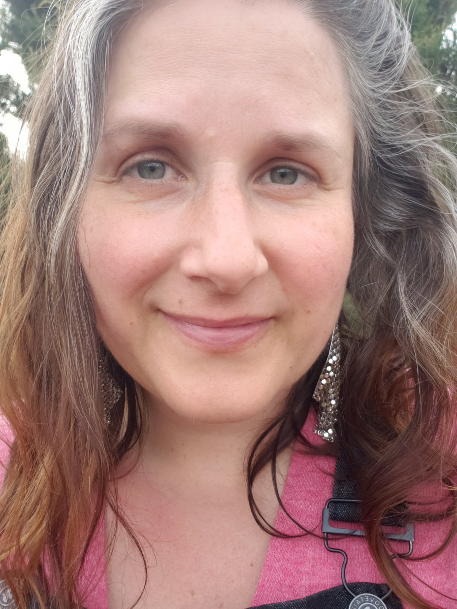A hag smiles with her naturally graying hair.