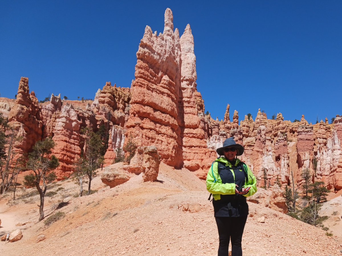 A happy hag hikes through pink pinnacles in the mystic desert.