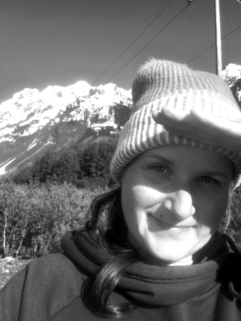 A smiling hag travels to see majestic mountain views.