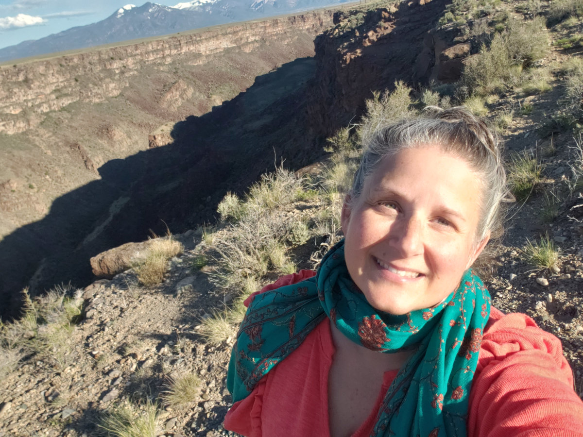 A smiling hag walks the rim of the Rio Grande rift in full sunshine.